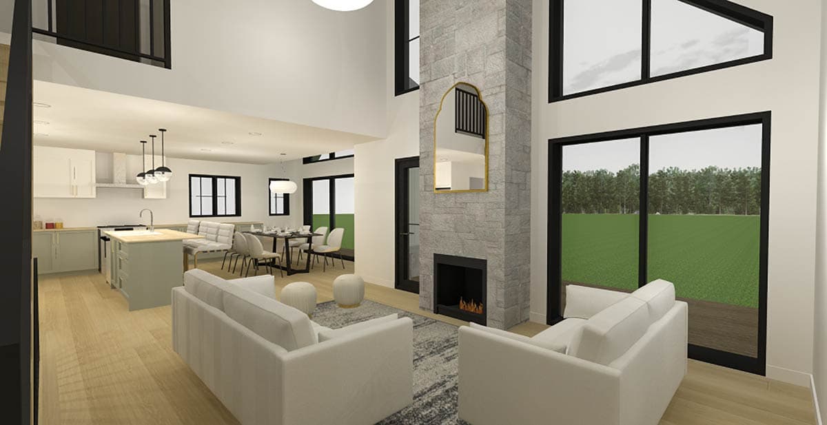 Open concept living area with fireplace, kitchen island, dining area, and two-story vaulted ceiling with large windows.