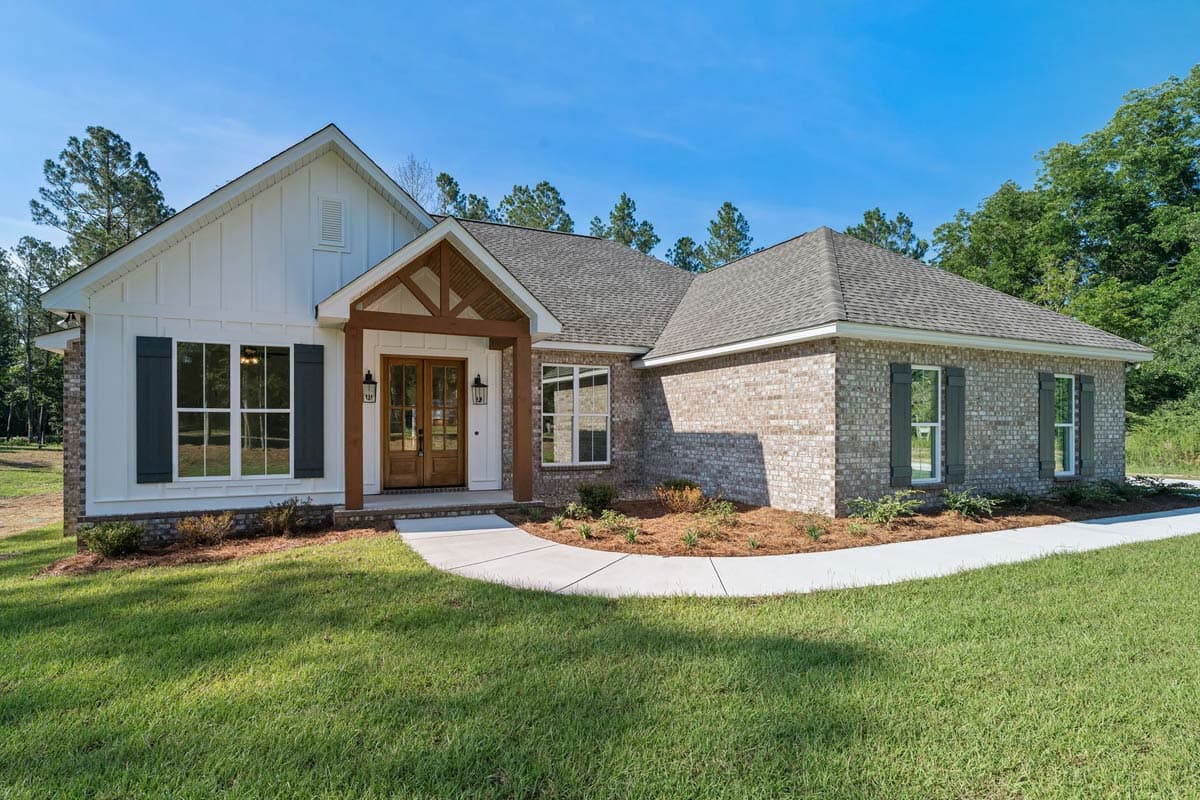 House plan exterior: Modern Farmhouse style, single-story with a gable roof, wood-trimmed porch, and brick accents.