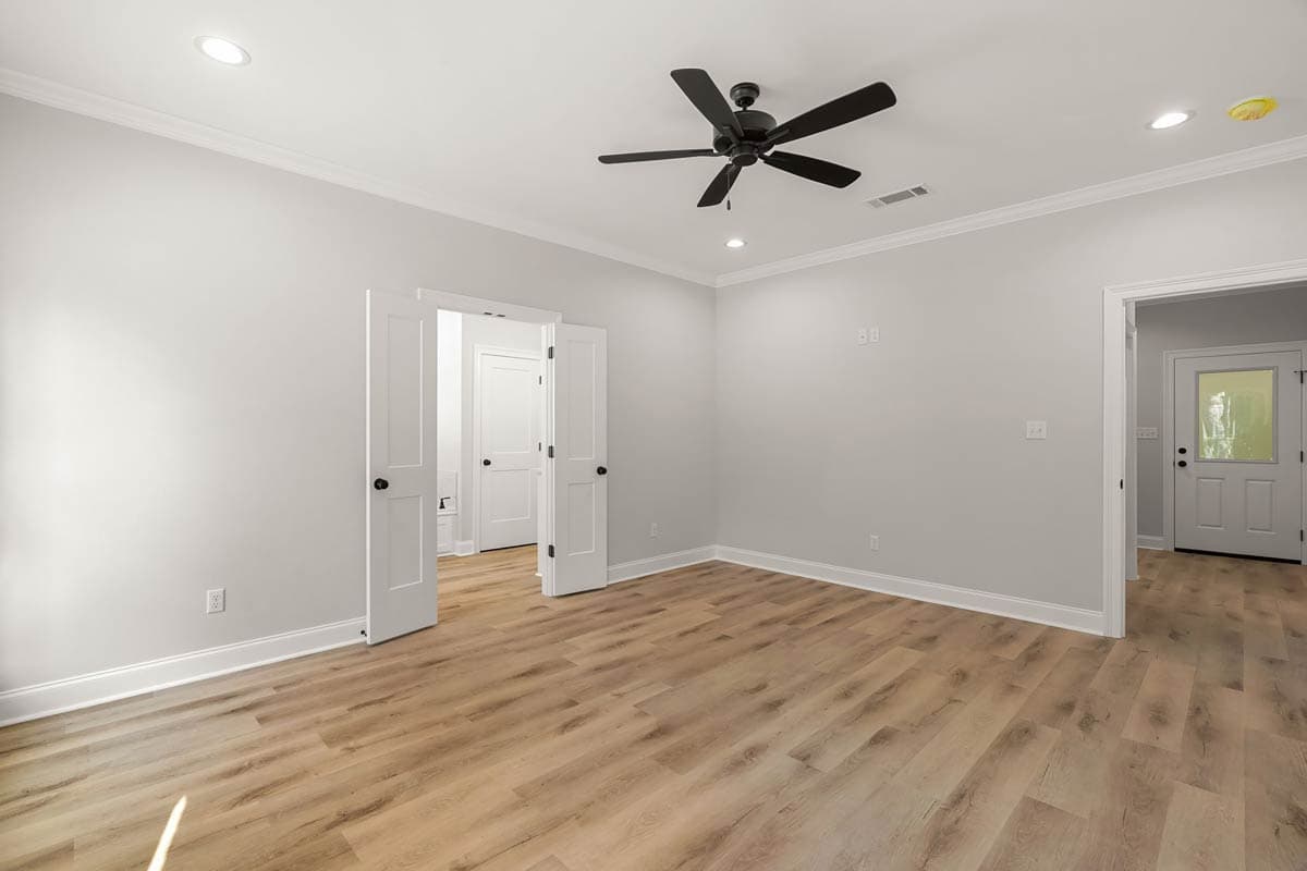 Interior view of a room with double doors, ceiling fan, recessed lighting, and wood-look flooring. Doorway to entryway visible.