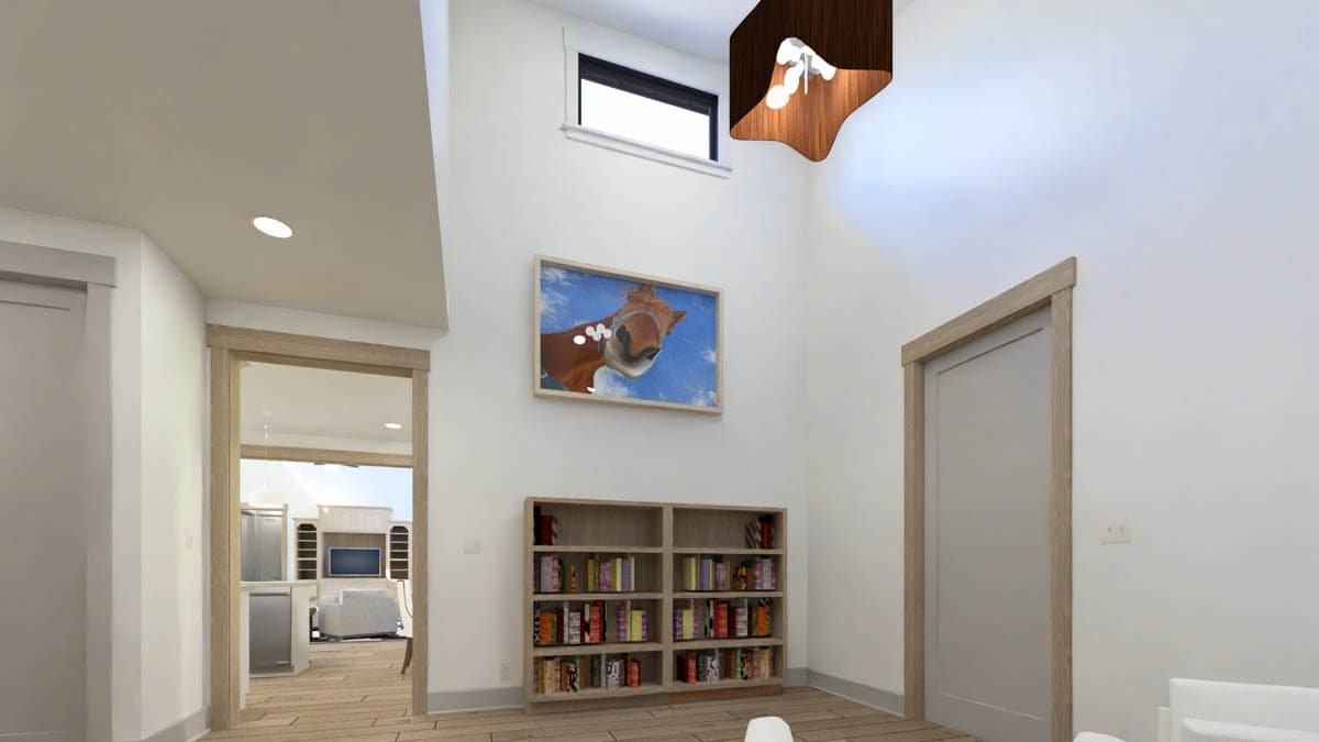 Interior view showing a hallway with a bookshelf, a painting, and an opening to a kitchen and living area.