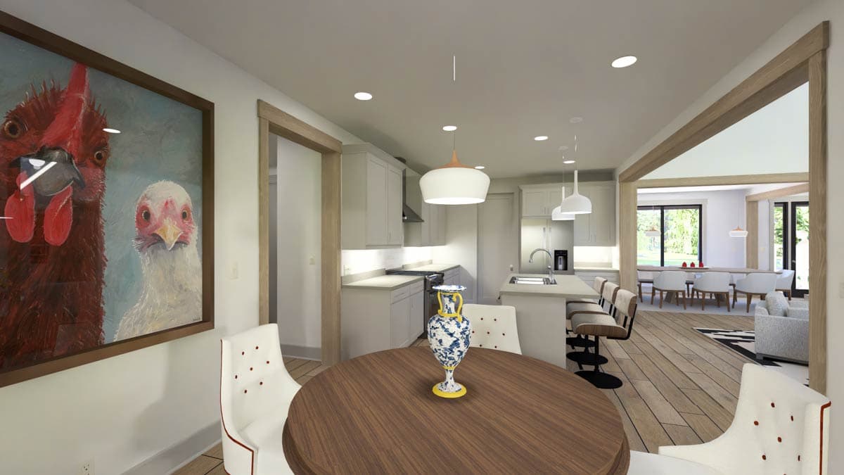 Interior view of a dining area and kitchen with island seating, modern cabinets, and open-concept layout leading to a dining room.