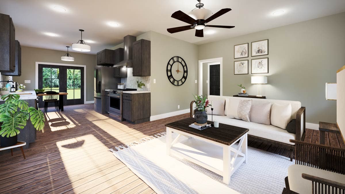 Interior view of an open-concept living area and kitchen, featuring dark wood cabinets, a large island, and a sectional sofa.