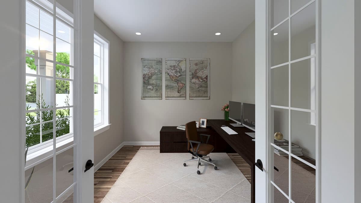 Home office with L-shaped desk, monitors, wall maps, and French doors with multiple panes.