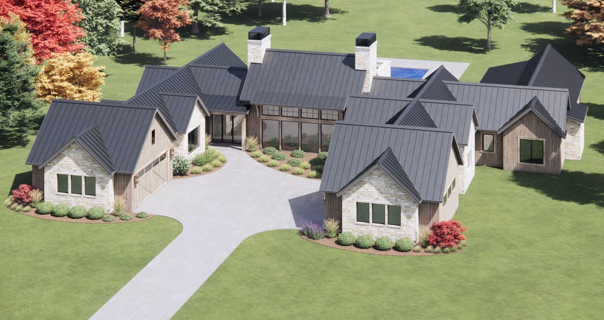 A modern, multi-gabled house with a light stone and wood exterior, dark gray metal roof, and a long driveway surrounded by green lawns and trees.
