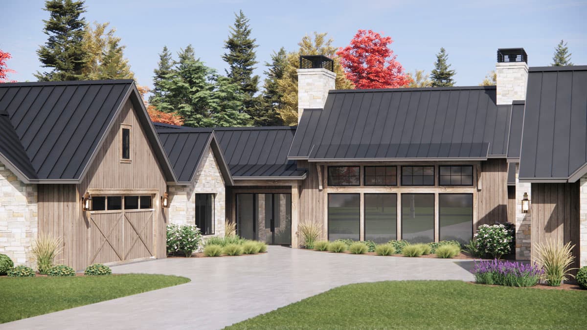 A modern, multi-gabled house with dark metal roofing and stone and wood siding, framed by a concrete driveway and lush landscaping.