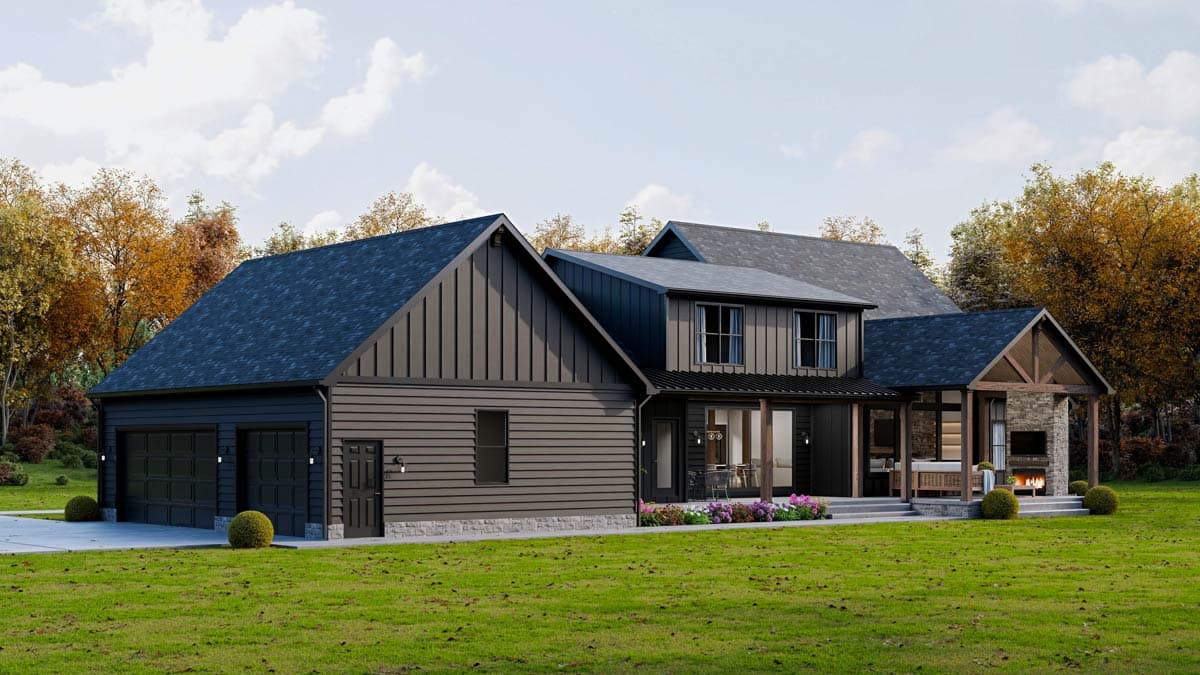 A modern, dark-colored house with a detached garage, a porch with a fireplace, and a manicured lawn under a partly cloudy sky.