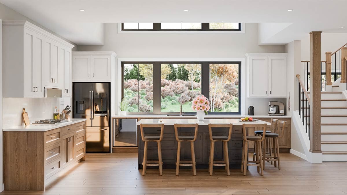 A bright, modern kitchen features a large island with bar stools, an open window with outdoor views, and a staircase leading upwards.