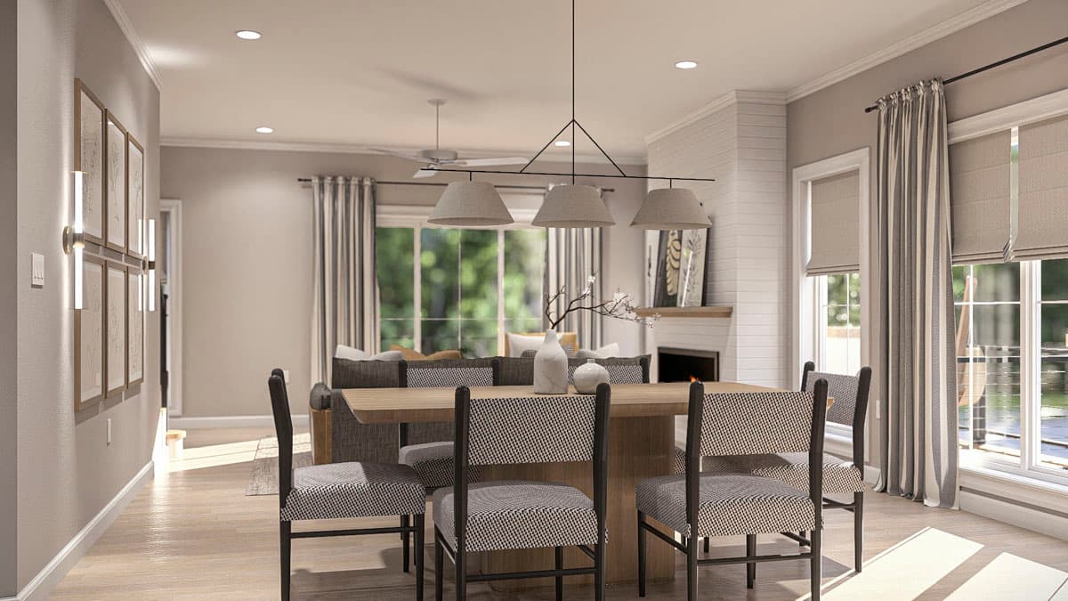 Dining room with chairs, wooden table, fireplace, and large windows with view to outdoors.