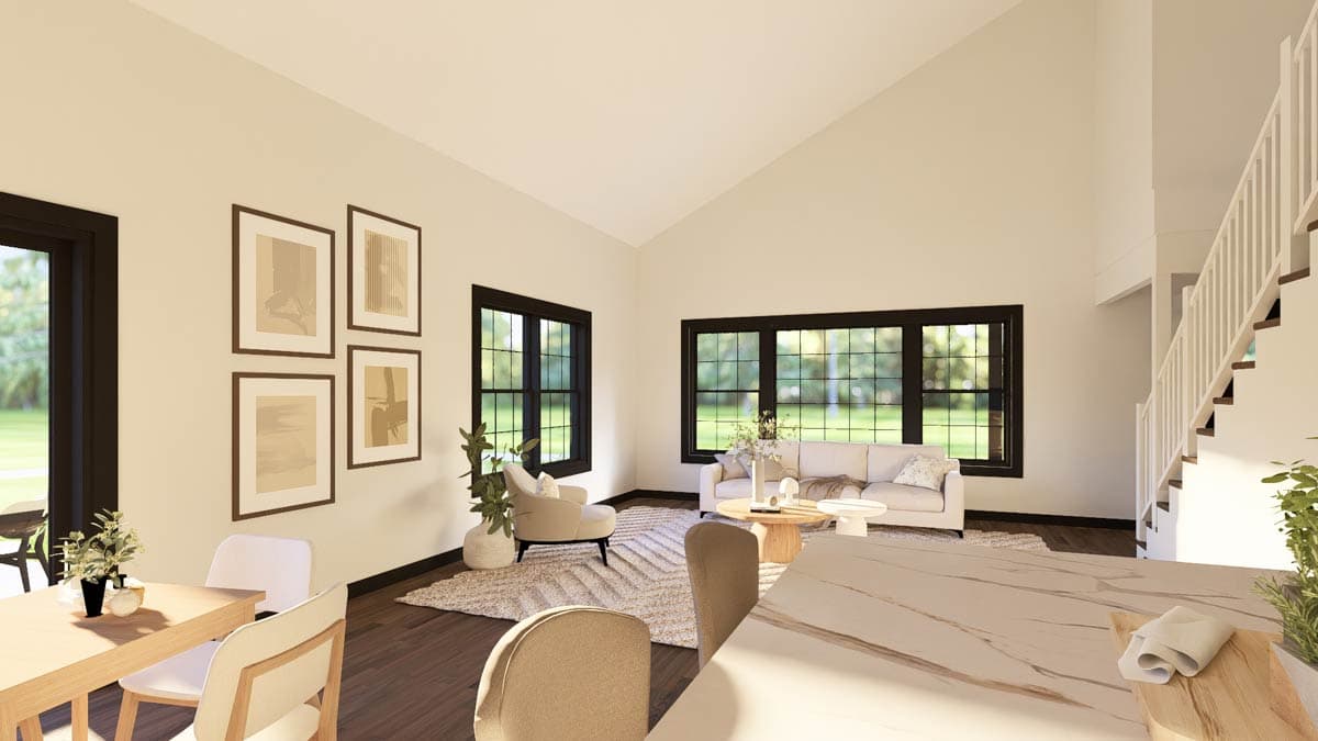 Open-concept living space with vaulted ceiling, large windows, a sofa, and a staircase.