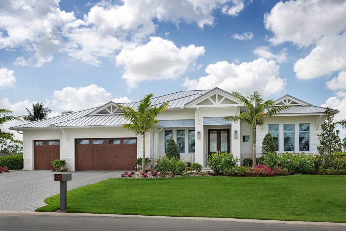 House plan exterior: Modern ranch with metal roof, dual garage doors with wood grain, and prominent gables.