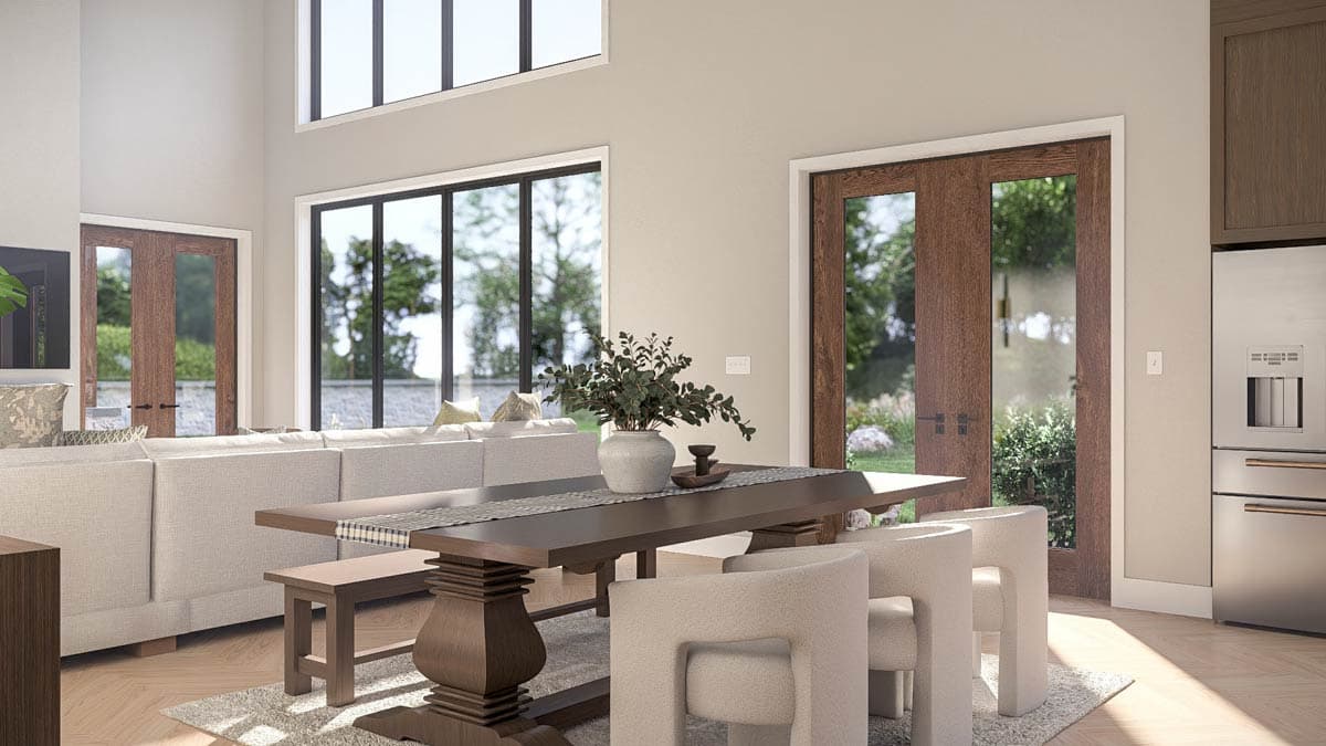 Open concept living area with large windows, double doors, dining table, and sectional sofa.