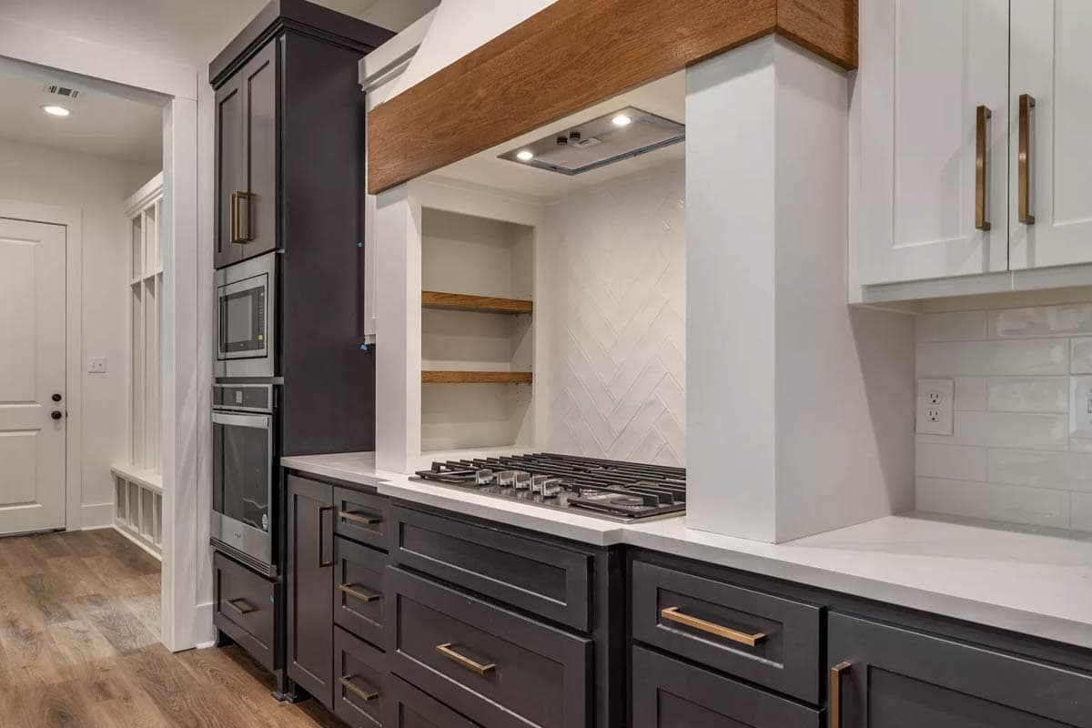 Kitchen with dark gray lower cabinets, white upper cabinets, gas range, and built-in oven and microwave.