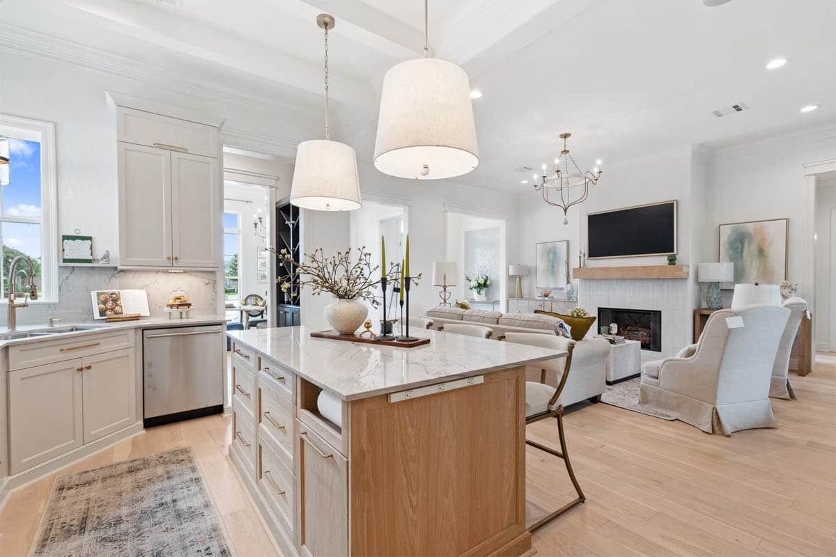 Open-concept living space with a kitchen island, fireplace with a wood mantel, and a living area with seating.