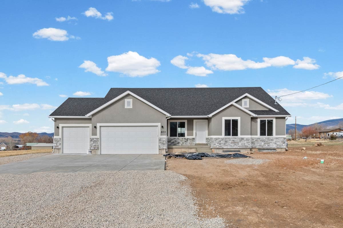 House plan exterior: Single-story home with a three-car garage, gabled dormer, and stone veneer.