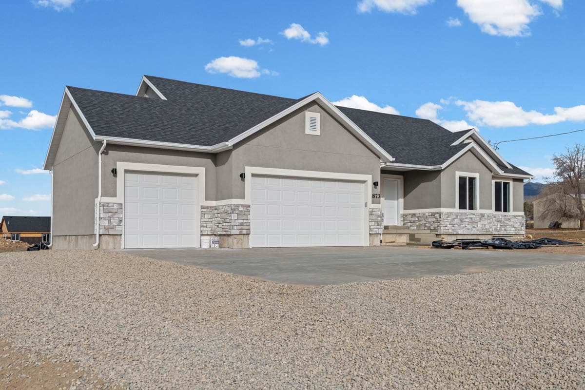 House plan exterior: Modern Ranch with a three-car garage, stucco siding, and stacked stone accents.