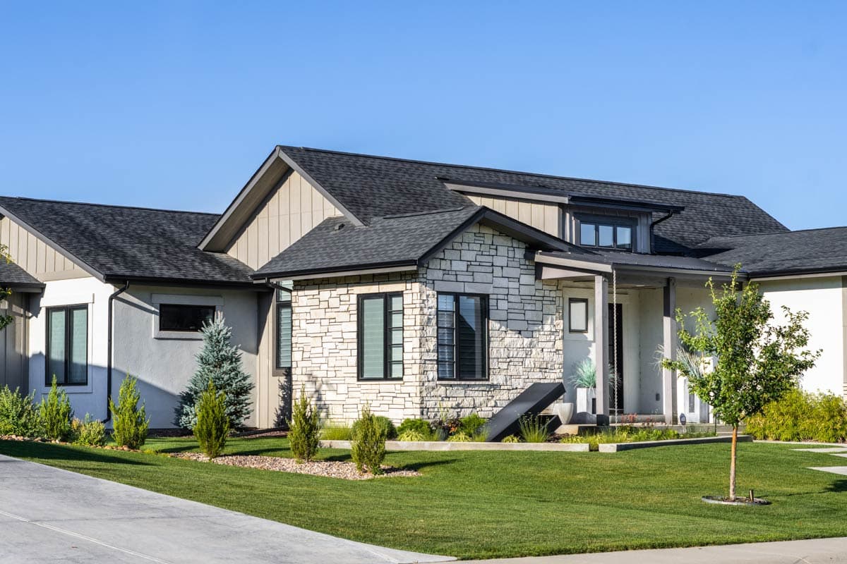 Modern house plan exterior with stone facade, gabled rooflines, and a covered entry porch.