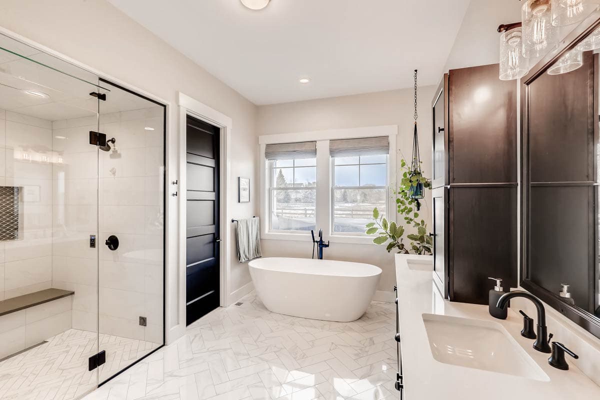 Bathroom interior featuring a glass-enclosed shower, freestanding tub, and double vanity with dark wood cabinets.