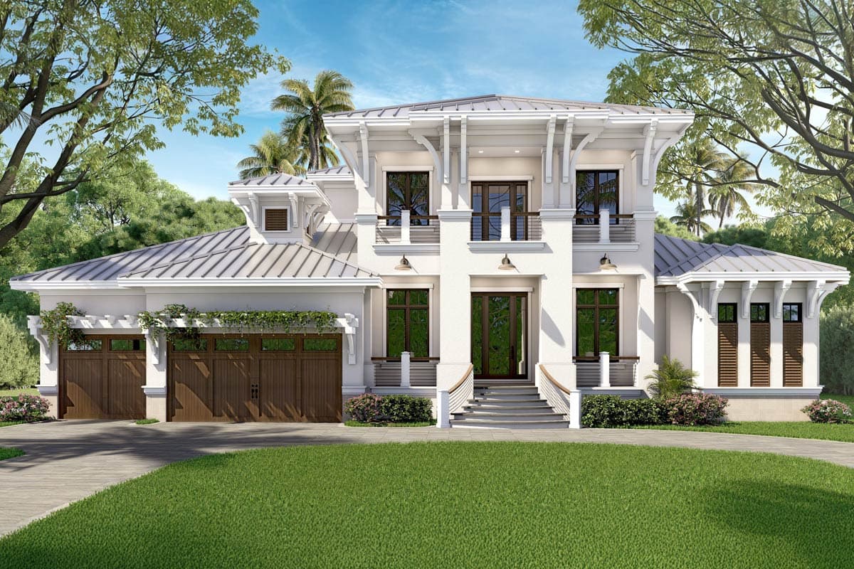 Two-story white house with brown wooden doors and trim. A green lawn leads to the entrance and driveway. Palm trees and greenery surround the home.