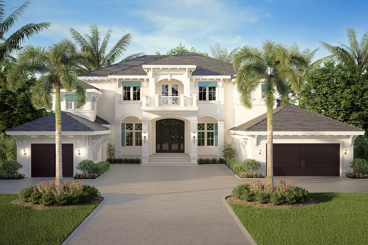 A large, luxury white house with dark gray roof, two garages, palm trees, and a paved driveway leading to the front door, under a blue sky.