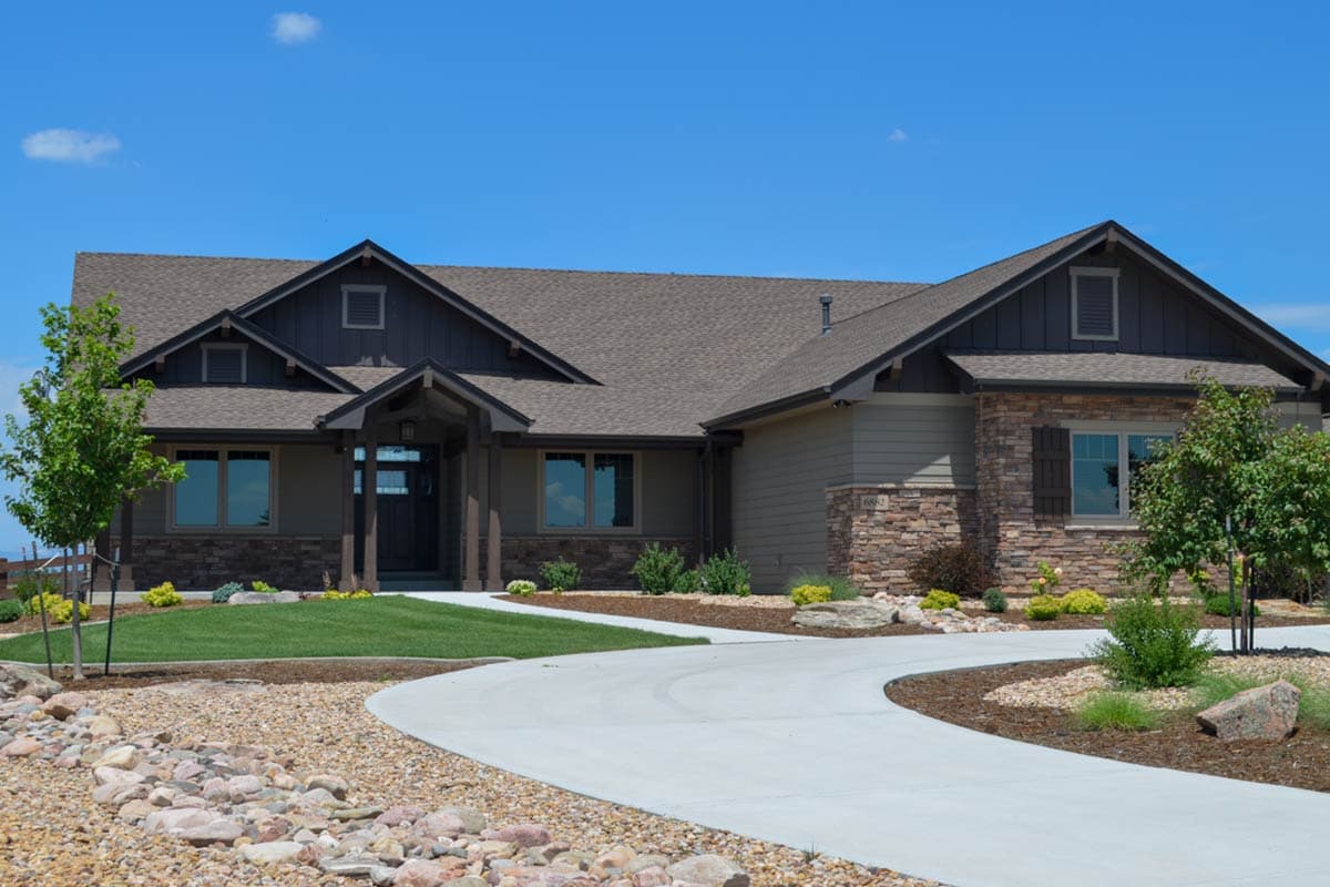House plan exterior with Craftsman style, single story, and multiple gables. Features include a covered entry and stone veneer accents.