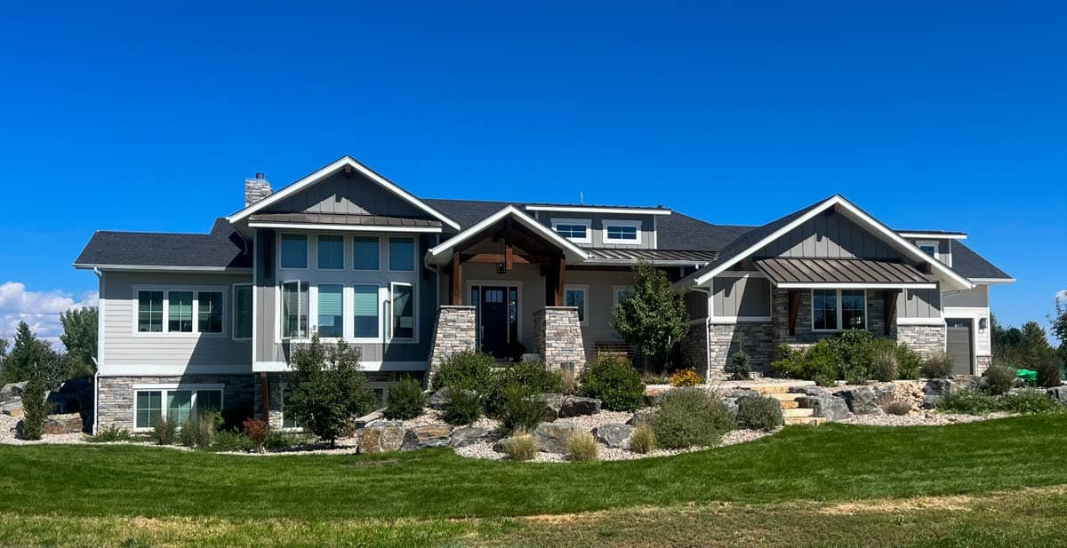 House plan exterior: Modern style, two stories, stone accents, gabled dormers, covered porch with exposed beams.