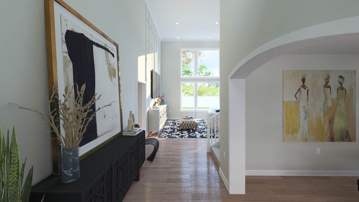 Interior view of a foyer with a high ceiling, large windows, and modern artwork.