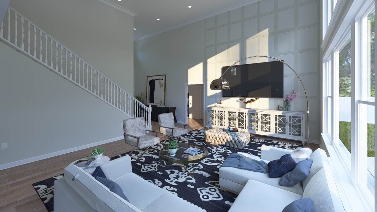 Great room with a vaulted ceiling, staircase, large windows, and a decorative paneled wall.