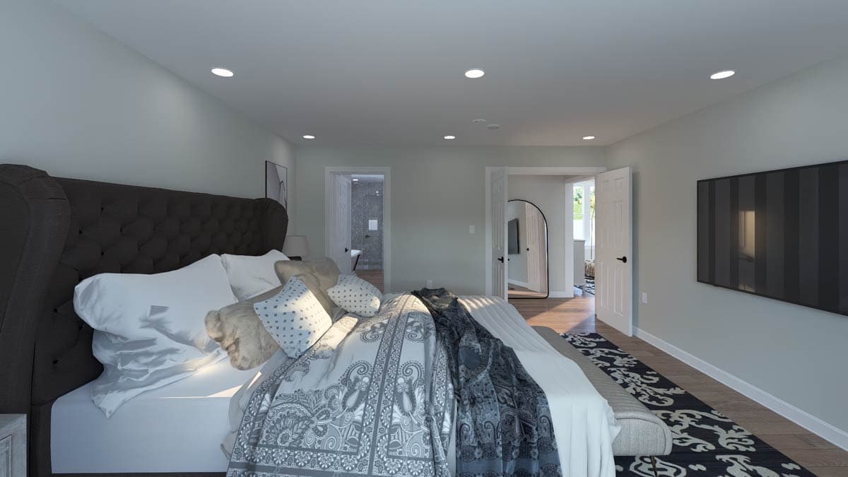 Primary bedroom with tufted headboard, white bedding, and adjoining bathroom and closet entrances.