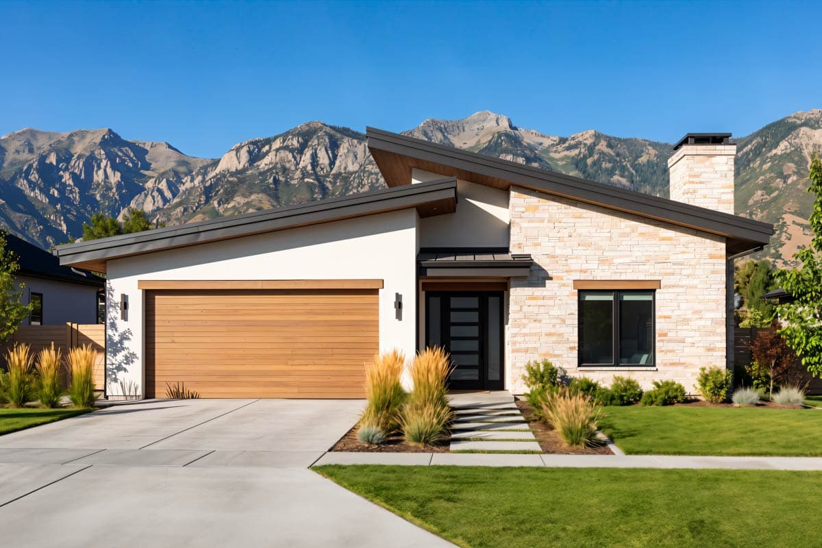 Modern house plan exterior with asymmetric rooflines, wood garage door, stone accent siding, and prominent chimney.