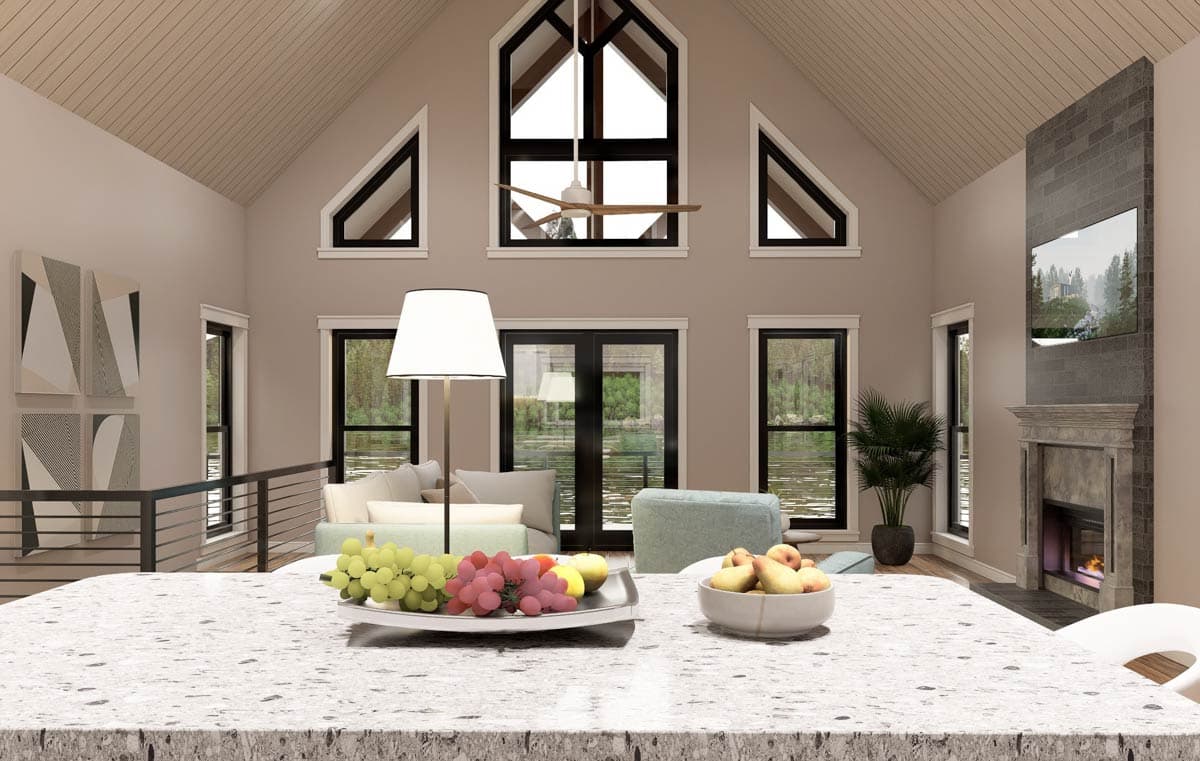 Great room interior with vaulted ceiling, stone fireplace, and large windows overlooking water.