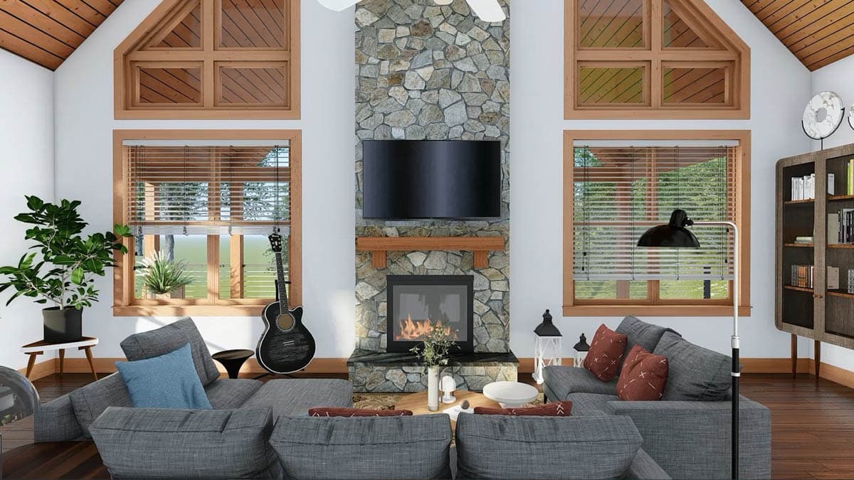 Great room with stone fireplace, wood-trimmed windows, vaulted ceiling with wood beams, and sectional sofas.