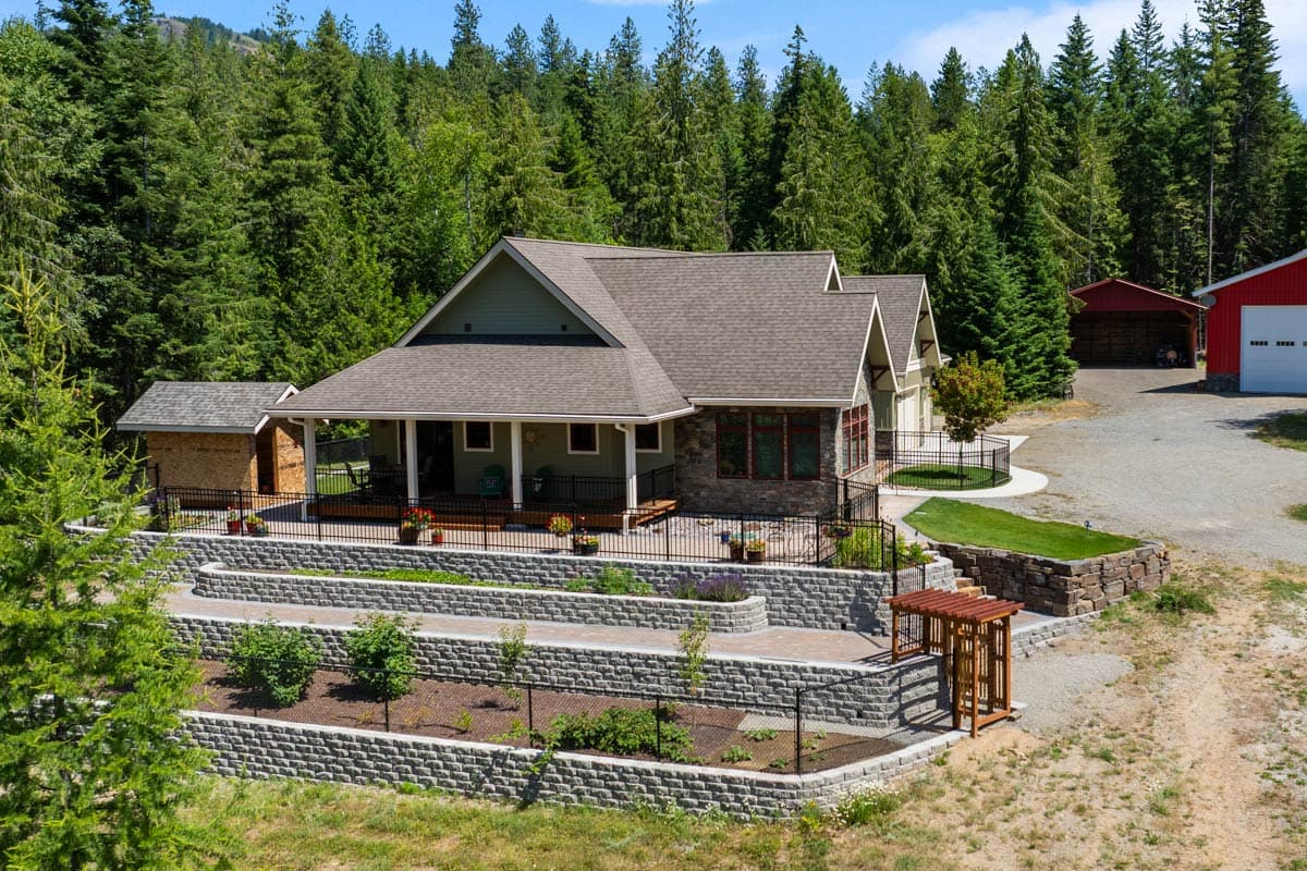 House plan exterior: Craftsman style, one-story with wraparound porch, stone accents, and multiple gables.