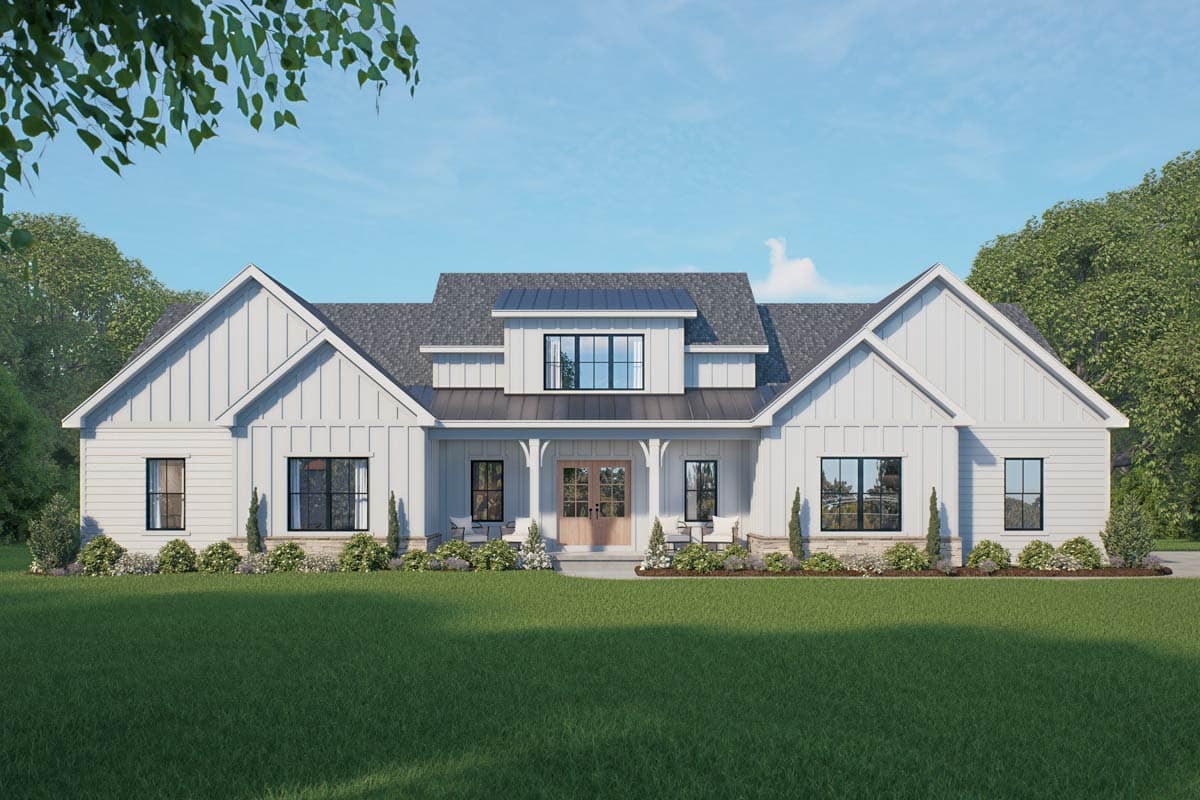 A modern white farmhouse with a symmetrical design. It has a dark gray roof, black window frames, and a wooden front door, all set against a blue sky.