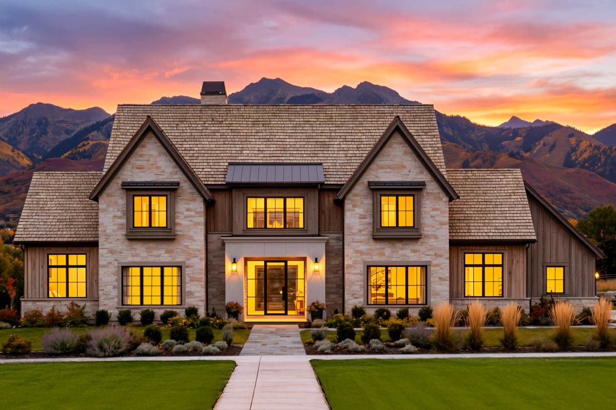House plan exterior featuring stone and wood siding, gabled dormers, and a central entry.