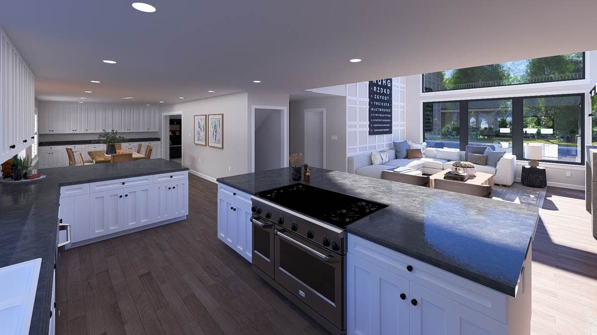 Open-concept living space featuring a large kitchen with island and range, flowing into a living area with sectional sofa and large windows.