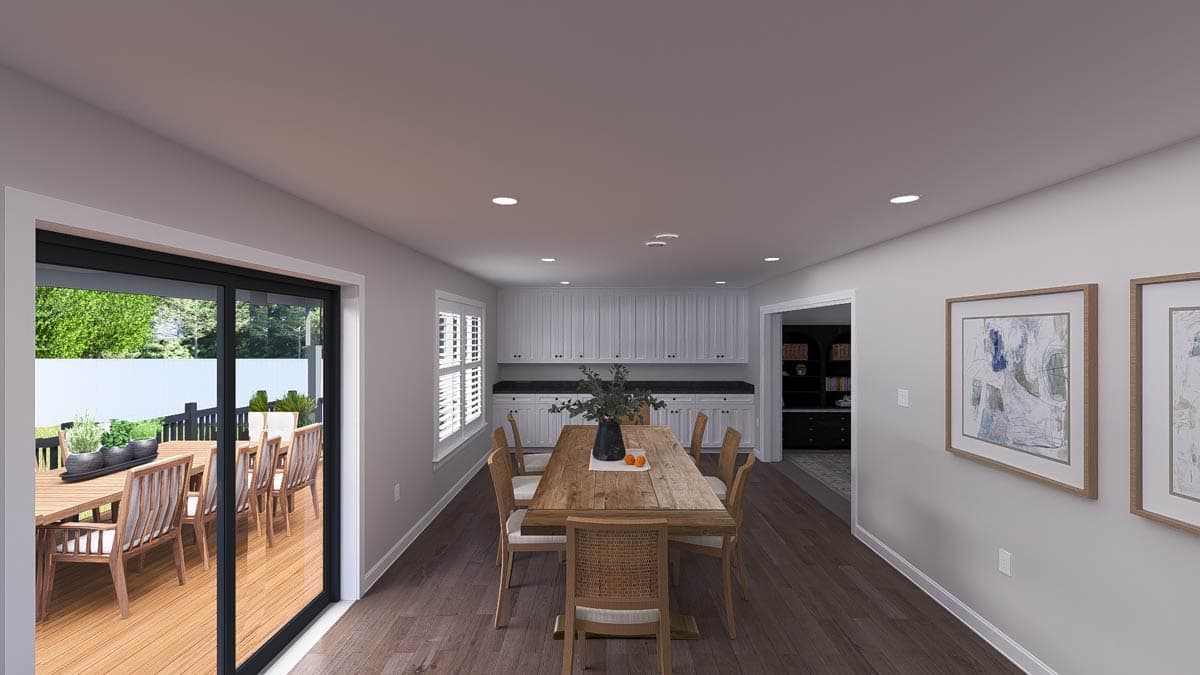 Dining area with large sliding glass doors to deck, wooden table and chairs, and white built-in cabinetry.