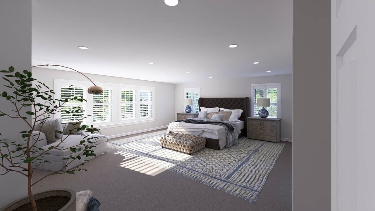 Bedroom with tufted headboard, large windows with shutters, seating area, and patterned rug.