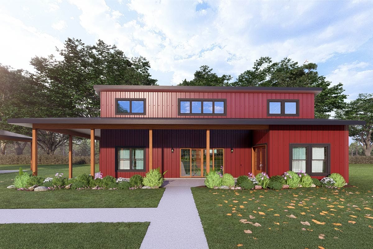 A modern, two-story home with a red metal exterior and a covered porch. The house has several windows, a pathway, and landscaping.