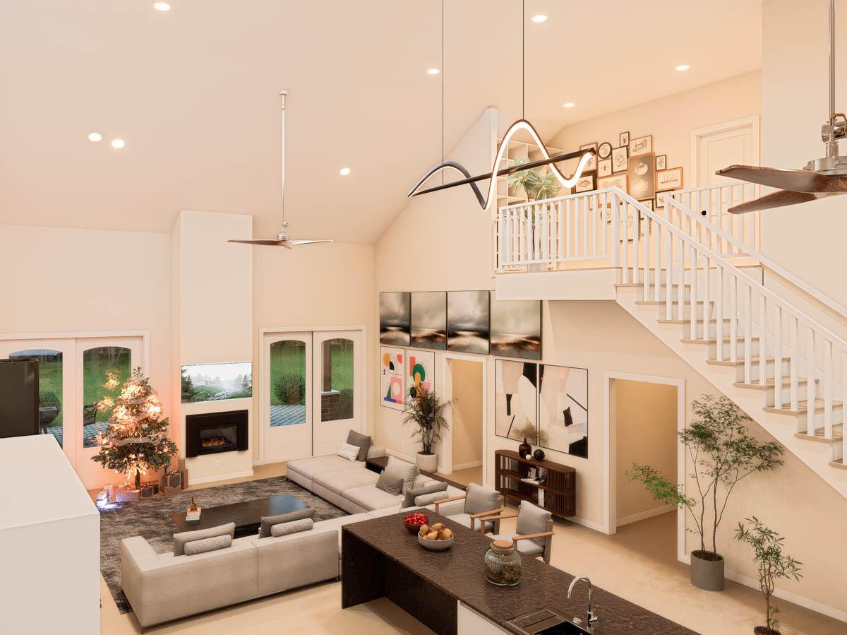 Open-concept living area with vaulted ceilings, fireplace, large sectional sofa, kitchen island, and open staircase with railing.