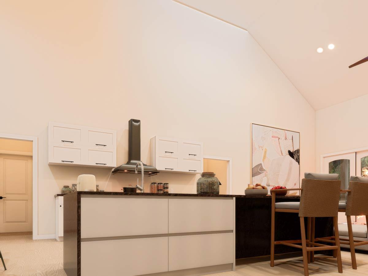 Modern kitchen with island, waterfall countertops, minimalist cabinetry, and a vaulted ceiling.