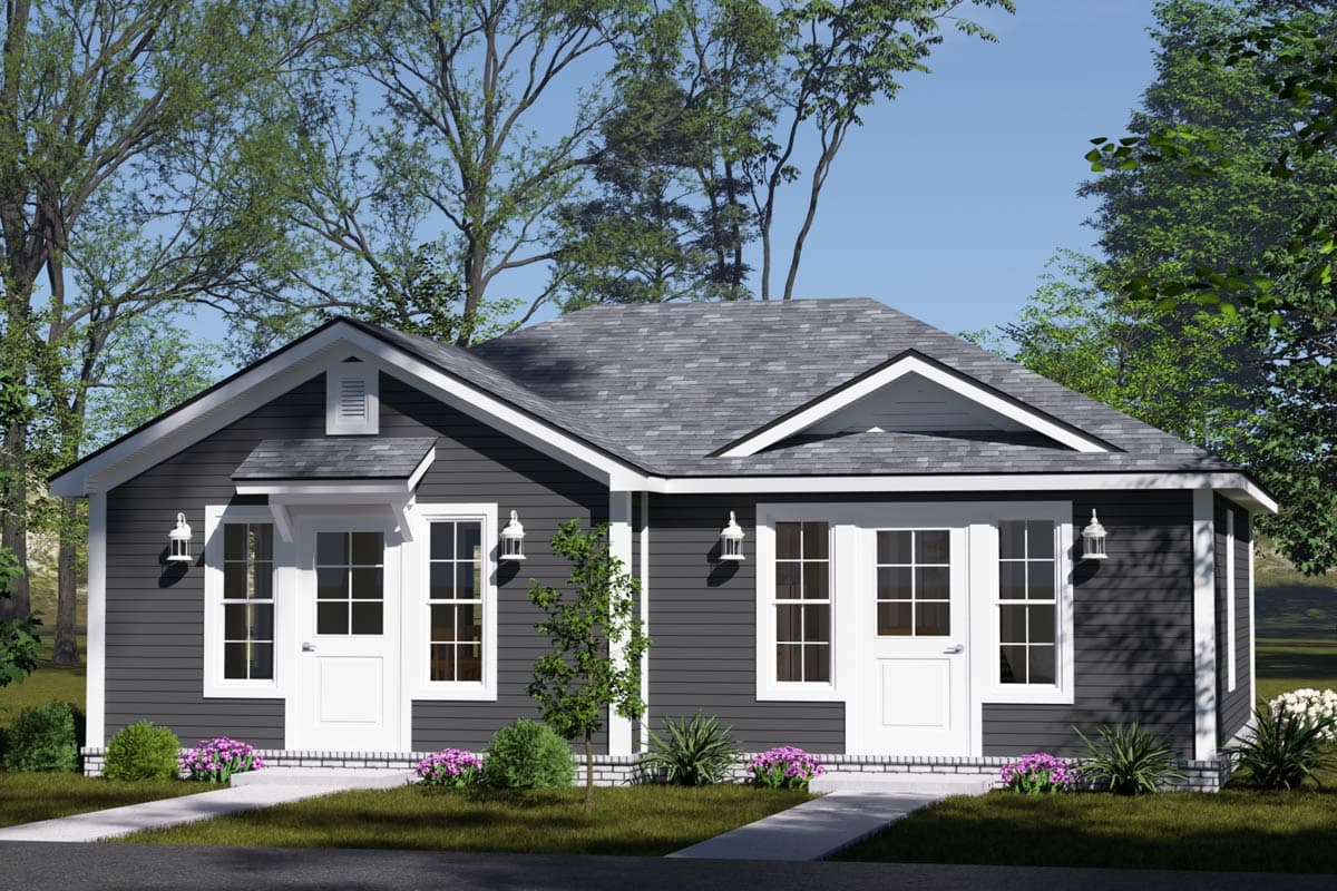 A dark gray, single-story house with white trim and multiple entry doors, set in a landscaped yard. Trees frame the house, clear sky overhead.