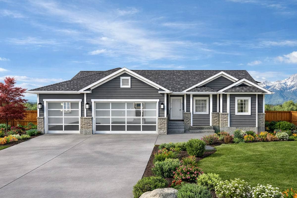 A modern gray house with a two-car garage, clear glass doors, and a well-manicured lawn. Mountains are visible in the background against a blue sky.