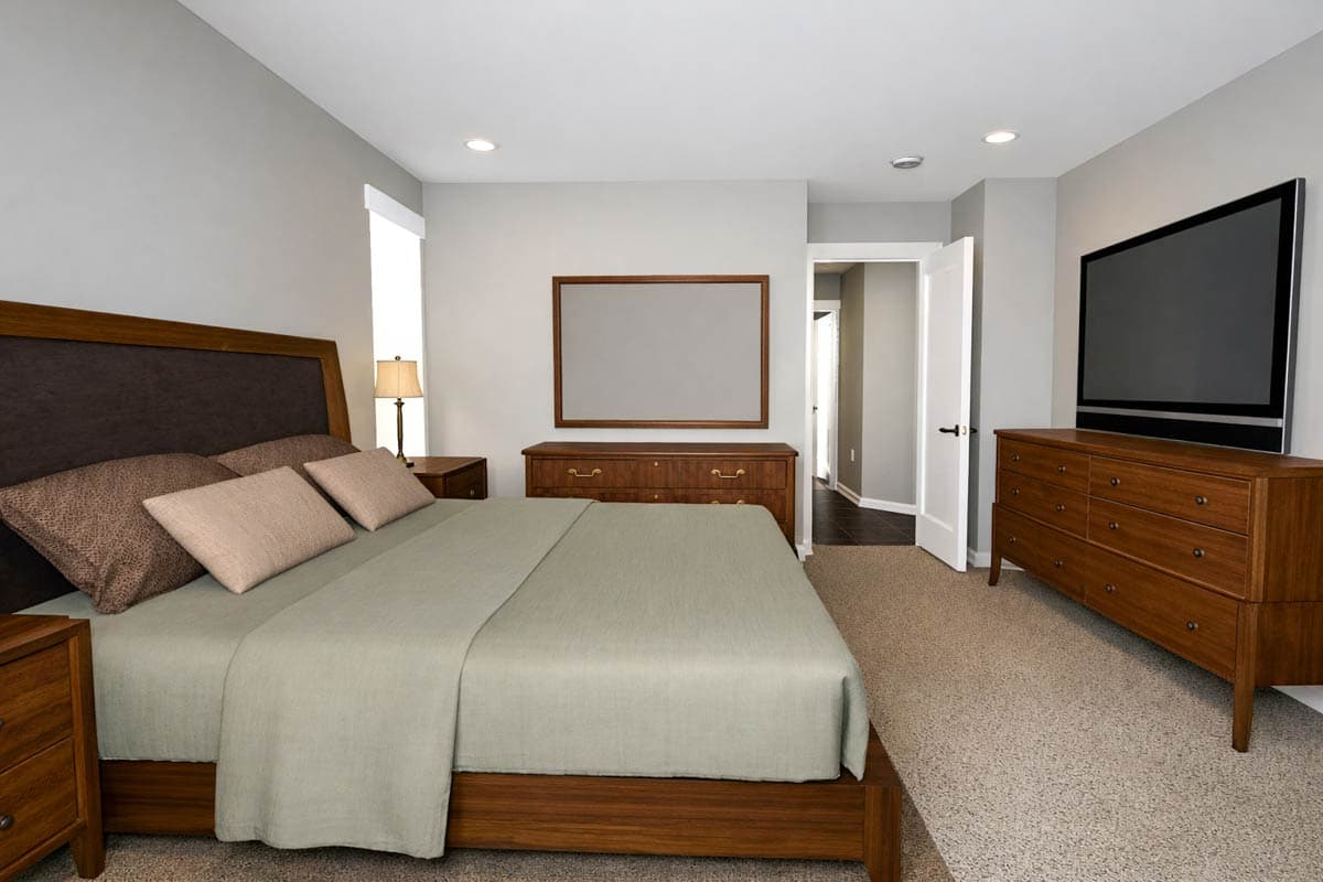 Interior view of a bedroom with a king-size bed, two dressers, and a television.