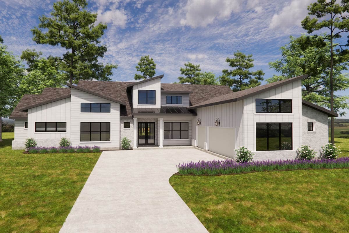 A modern, two-story house with white siding, dark trim, and a prominent driveway. Lush landscaping and trees frame the home under a blue sky.