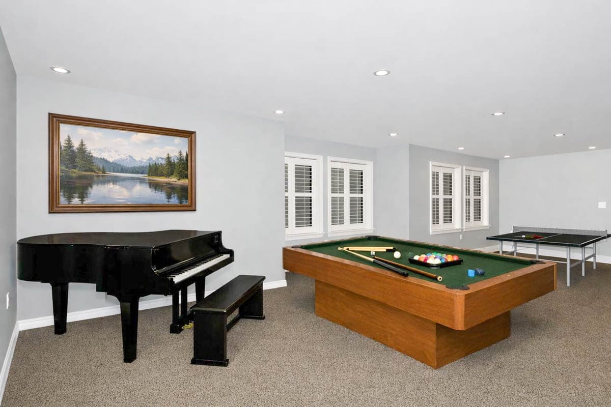 Recreation room interior with grand piano, pool table, and ping pong table.