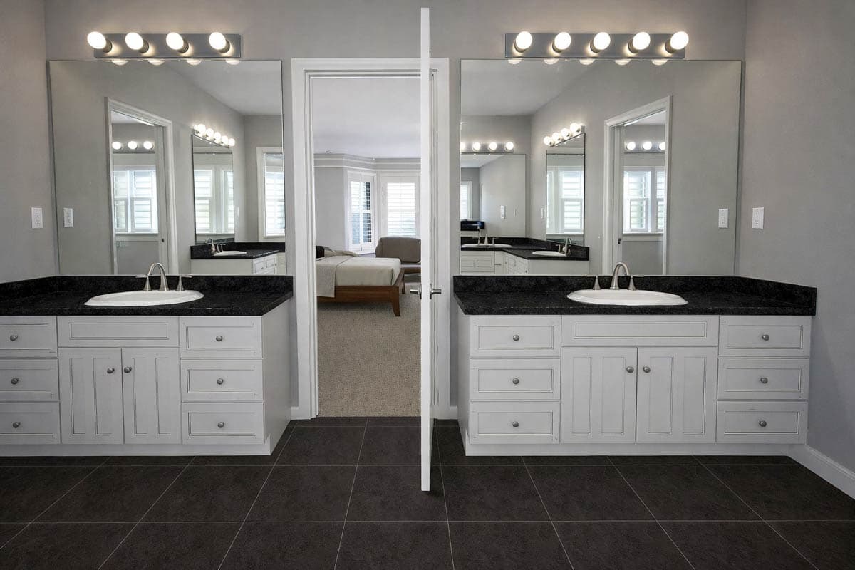 Master bathroom with double vanity, granite countertops, and view into bedroom.