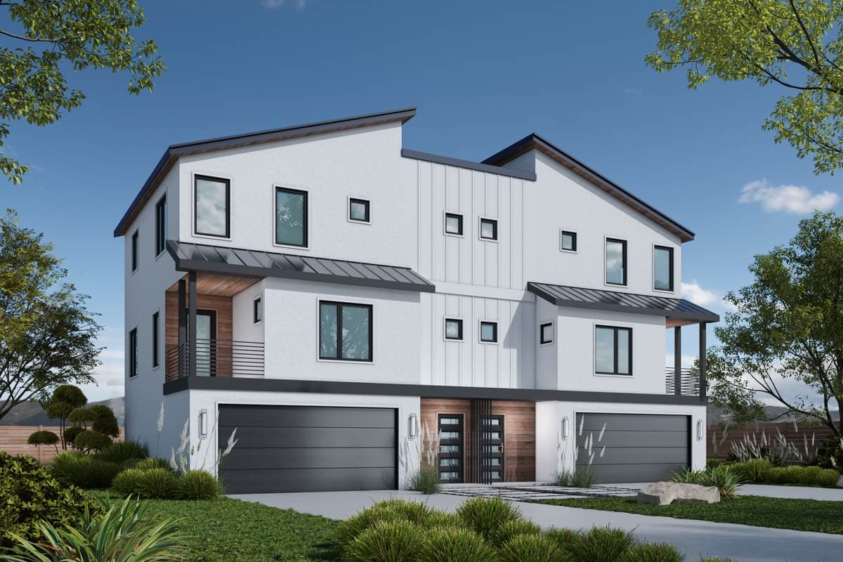 Modern white multi-unit residential building with dark garage doors and accents. Landscaping includes manicured bushes and trees under a clear sky.