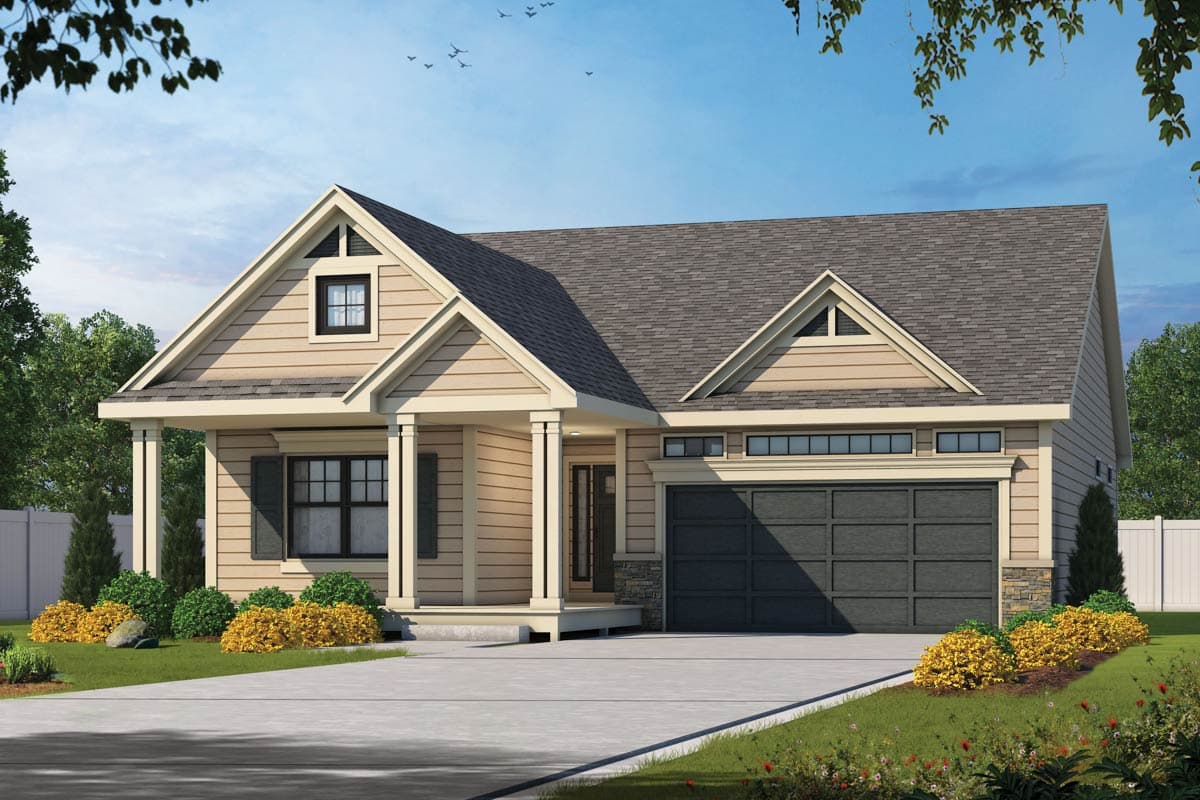 A beige-sided house with a dark gray roof. The house has a garage and a porch supported by white columns. Landscaping includes green bushes.