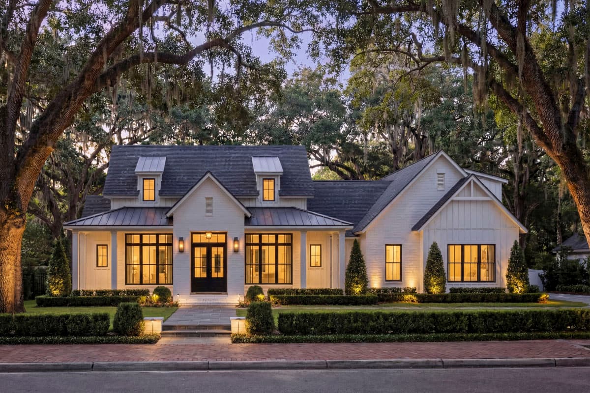 House plan exterior. Modern Farmhouse style with a two-story layout. Features include a front porch, dormers, gables, and a dark roofline.