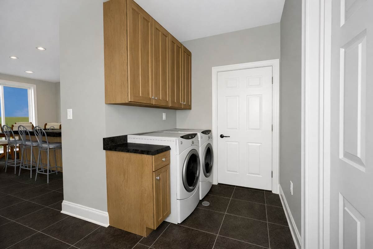 Laundry room with stacked washer/dryer, wood cabinets, granite countertop, and a white paneled door.
